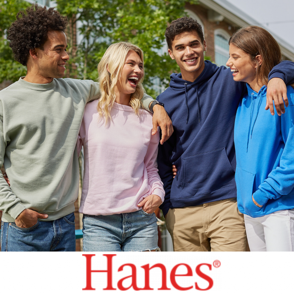 A group of four people wearing casual sweatshirts and pants are hanging out together and laughing. They all have their arms around each other. Below is the Hanes logo