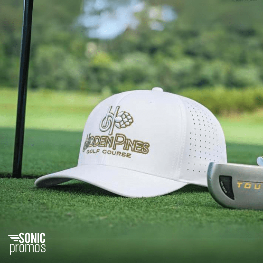 A white custom logo branded golf hat sits on a golf green
