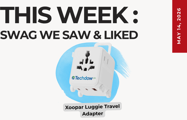 Hero image for this week: 'Swag We Saw & Liked' featuring a white Xoopar Luggie Travel Adapter on a blue paint splash, May 14, 2016 badge on the side.