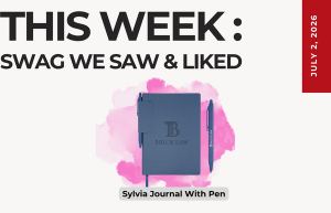 Weekly roundup graphic: 'THIS WEEK: SWAG WE SAW & LIKED' with date July 2, 2026; blue journal and pen over pink splash, caption 'Sylvia Journal With Pen'