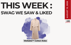 Poster advertising a beige Wellable Cotton Robe centered on a purple watercolor splash with a bold headline about the week’s swag